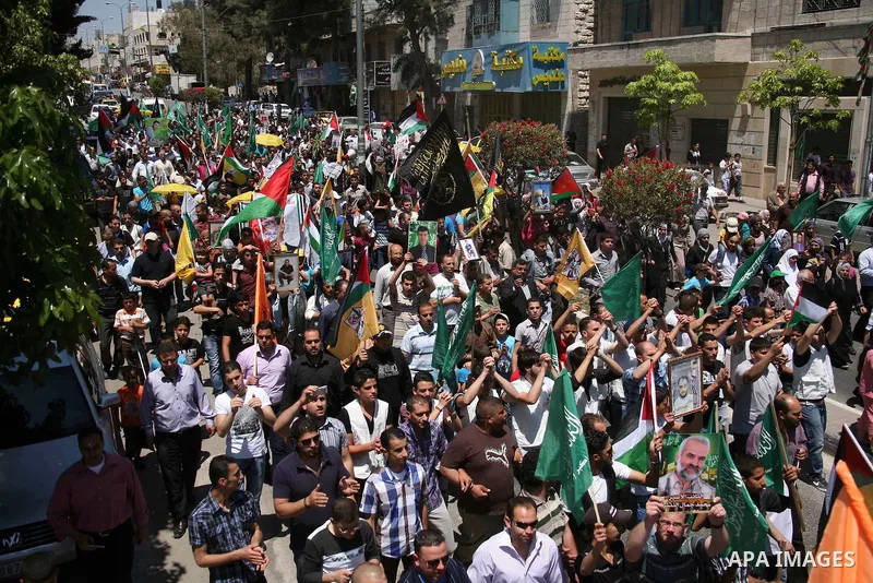 Palestinians participate a demonstration, and hold portraits of prisoners held in Israeli jails, solidarity with prisoners who have been waging a hunger strike in Israeli jails, on May 11, 2012, in the West Bank city of...
