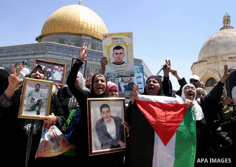 Palestinians hold portraits of relatives held in Israeli jails during a protest on the compound known to Muslims as Noble Sanctuary and to Jews as Temple Mount in Jerusalem's Old City, to show solidarity with prisoners o...