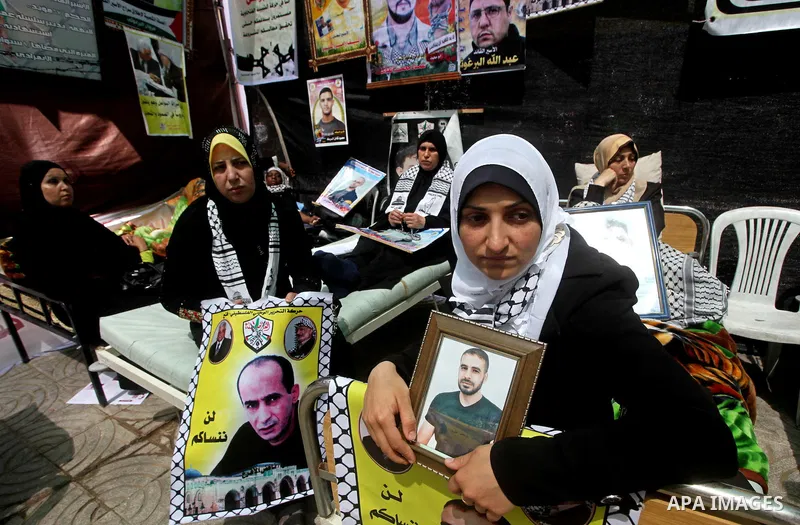 Palestinian women hold pictures of their jailed relatives during a sit-in in Gaza city in support of over 1,550 prisoners observing a hunger strike to demand better conditions in Israeli jails on May 12, 2012. The World...