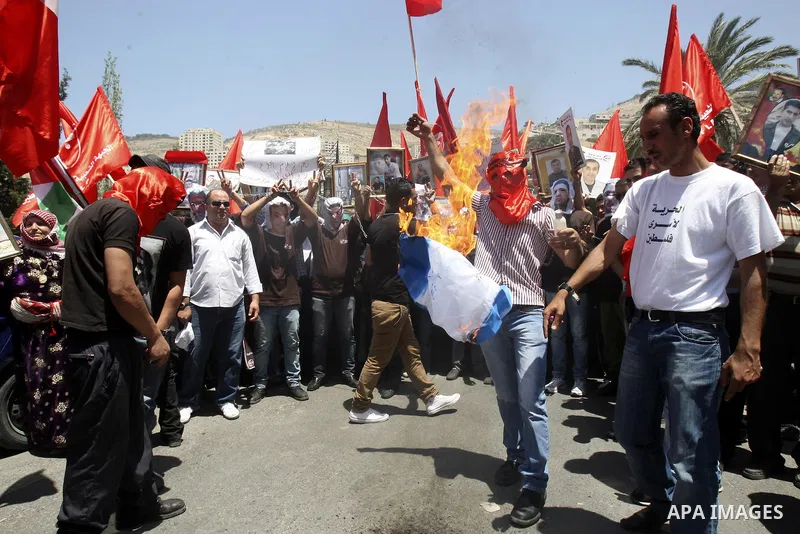 Palestinian protesters cover their faces with pictures of Palestinian prisoners during protests in the center of Nablus City , 12 May 2012 for the release of prisoners held in Israeli jails. Hundreds of Palestinians serv...