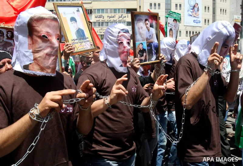 Palestinian protesters cover their faces with pictures of Palestinian prisoners during protests in the center of Nablus City , 12 May 2012 for the release of prisoners held in Israeli jails. Hundreds of Palestinians serv...