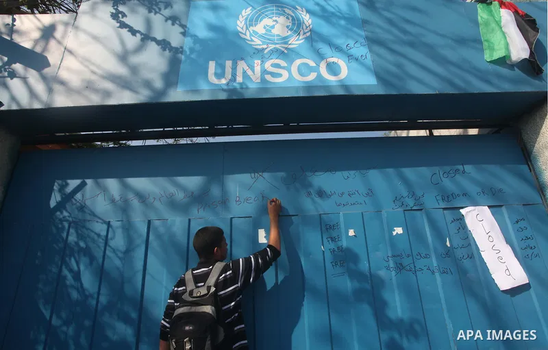 A Palestinian youth writes on the plaque of the Office of the United Nations Special Coordinator (UNSCO) headquarters in Gaza, as they forced the offices to close for two hours in solidarity with over 1,550 prisoners obs...