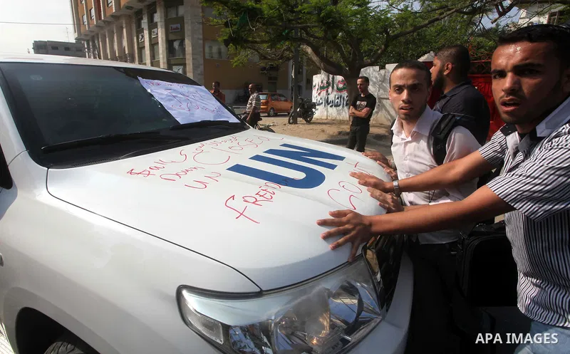 A Palestinian youth writes on the plaque of the Office of the United Nations Special Coordinator (UNSCO) headquarters in Gaza, as they forced the offices to close for two hours in solidarity with over 1,550 prisoners obs...