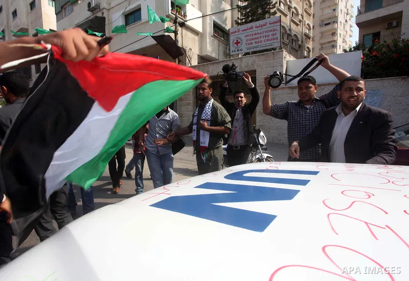 A Palestinian youth writes on the plaque of the Office of the United Nations Special Coordinator (UNSCO) headquarters in Gaza, as they forced the offices to close for two hours in solidarity with over 1,550 prisoners obs...