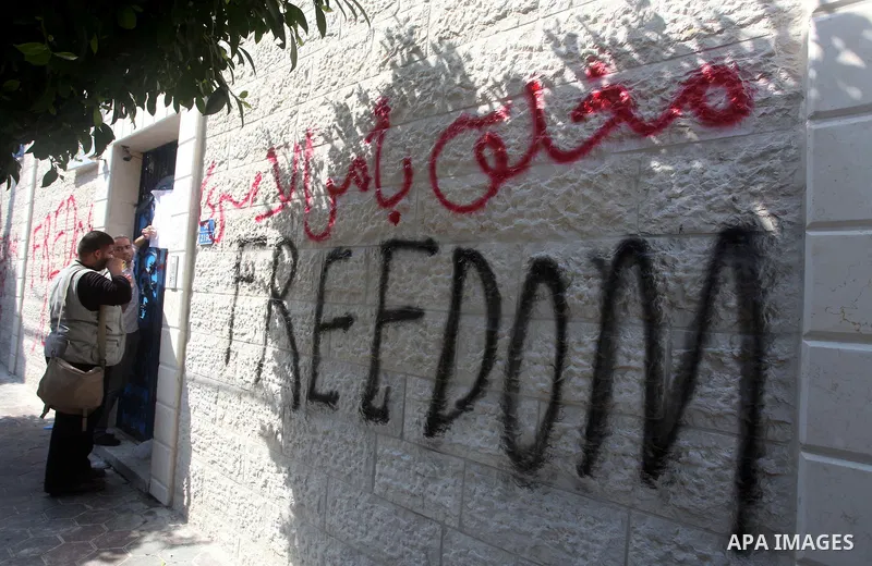 A Palestinian writes outside the headquarters of the International Committee of the Red Cross (ICRC) in Gaza as protestors forced the offices to close for two hours in solidarity with over 1,550 prisoners observing a hun...