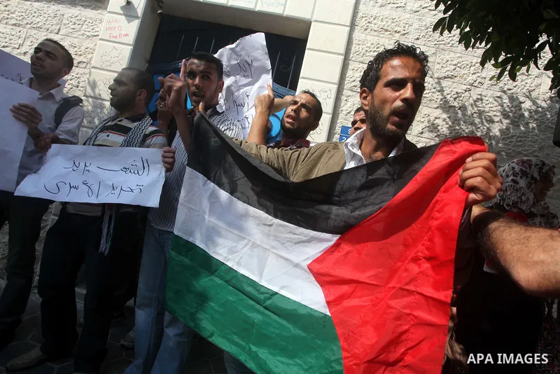 Palestinian men stand outside the headquarters of the International Committee of the Red Cross (ICRC) in Gaza as they forced the offices to close for two hours in solidarity with over 1,550 prisoners observing a hunger s...