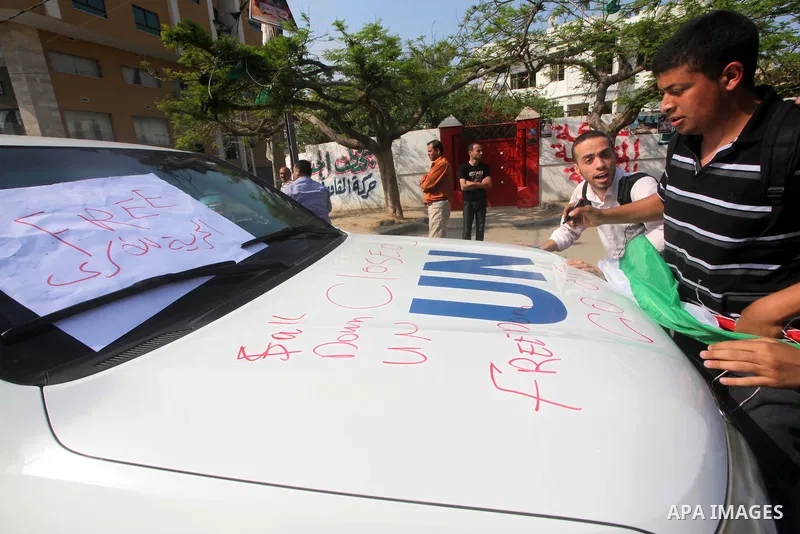 A Palestinian youth writes on the plaque of the Office of the United Nations Special Coordinator (UNSCO) headquarters in Gaza, as they forced the offices to close for two hours in solidarity with over 1,550 prisoners obs...