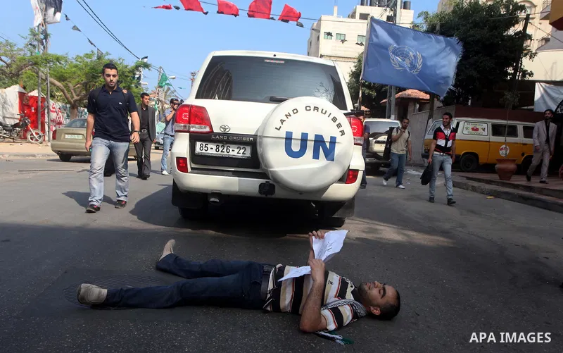 A Palestinian protestor lies on the ground during a protest in front of the Red Cross headquarters in Gaza City to show solidarity with Palestinian prisoners held in Israeli jails May 13, 2012. Hundreds of Palestinians o...