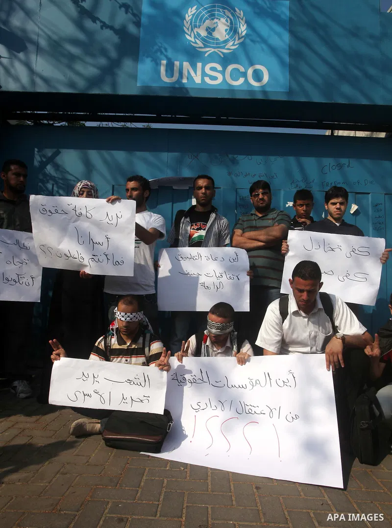 Palestinian men stand outside the headquarters of the International Committee of the Red Cross (ICRC) in Gaza as they forced the offices to close for two hours in solidarity with over 1,550 prisoners observing a hunger s...