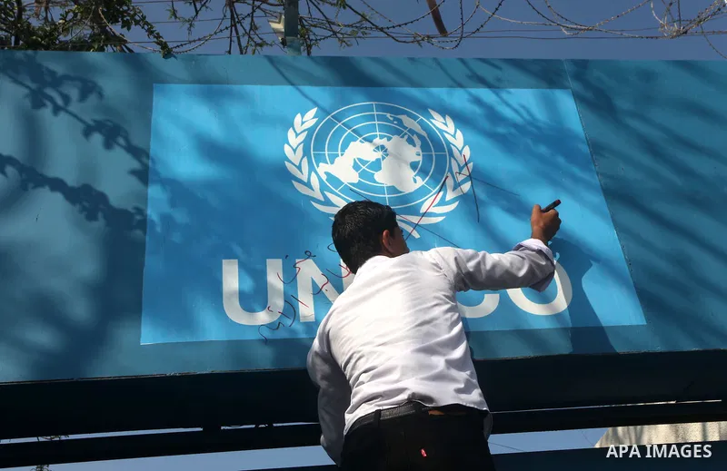 A Palestinian youth writes on the plaque of the Office of the United Nations Special Coordinator (UNSCO) headquarters in Gaza, as they forced the offices to close for two hours in solidarity with over 1,550 prisoners obs...