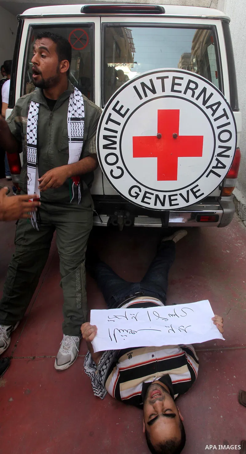 A Palestinian protestor lies on the ground during a protest in front of the UNESCO in Gaza City to show solidarity with Palestinian prisoners held in Israeli jails May 13, 2012. Hundreds of Palestinians on hunger strike...