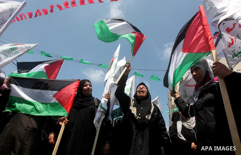 Palestinian protesters hold up signs outside the headquarters of the International Committee of the Red Cross (ICRC) during a protest in Gaza City, to show solidarity with Palestinian prisoners held in Israeli jails, May...