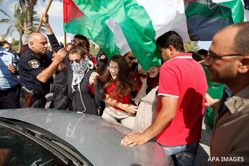 Dozens of Palestinian, Israeli and foreign activists hold Palestinian flags as they gather near the Maale Adumim settlement in West Bank on May 13, 2012 during a demonstration in support of Palestinian prisoners observin...