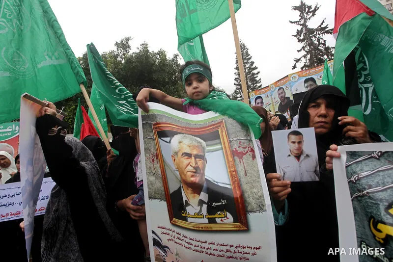 Palestinian women hold pictures of incarcerated relatives in a rally to show solidarity with prisoners held in Israeli jails, in Gaza City May 14, 2012. One in three of the 4,800 Palestinians serving time in Israeli jail...