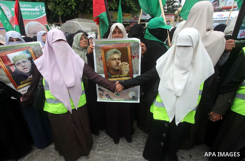 Palestinian women hold pictures of incarcerated relatives in a rally to show solidarity with prisoners held in Israeli jails, in Gaza City May 14, 2012. One in three of the 4,800 Palestinians serving time in Israeli jail...