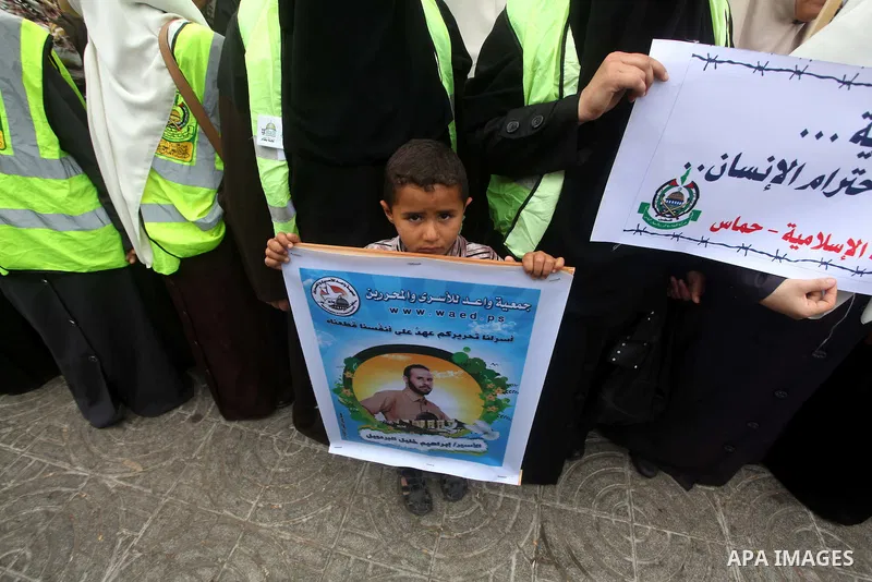 A Palestinian child holds pictures of incarcerated relatives in a rally to show solidarity with prisoners held in Israeli jails, in Gaza City May 14, 2012. One in three of the 4,800 Palestinians serving time in Israeli j...