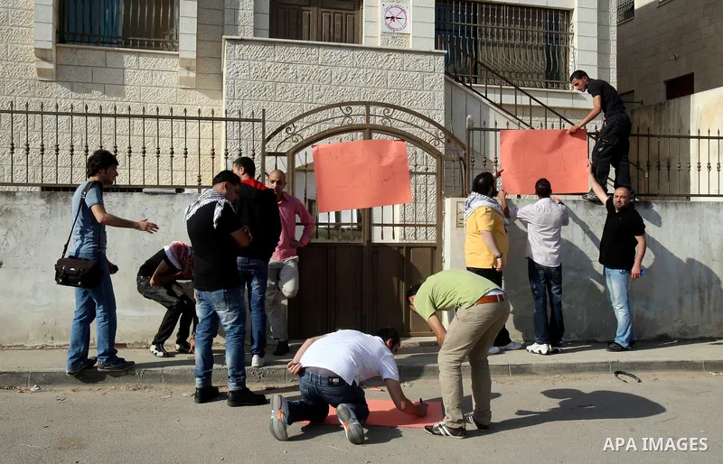 Palestinians attached a banners outside the headquarters of the International Committee of the Red Cross (ICRC) in the West Bank City of Nablus, 14 May 2012, as they forced the offices to close for three hours in solidar...