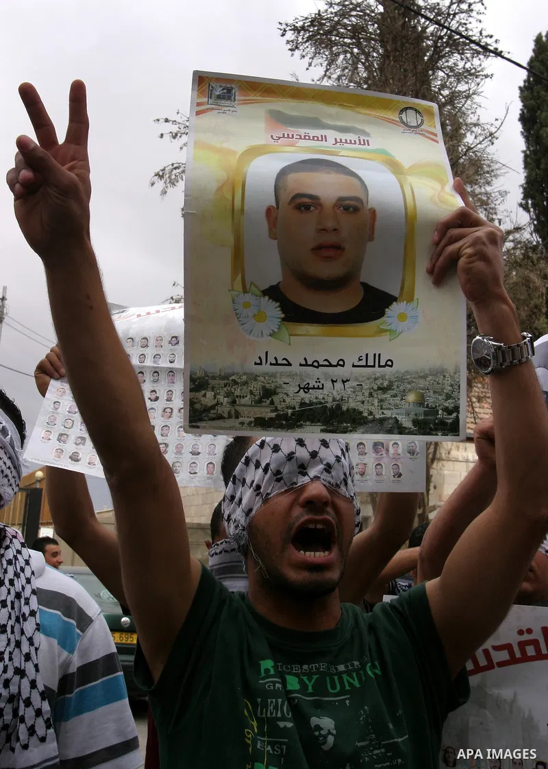 Palestinians hold pictures and portraits of their relatives held in Israeli jails during a protest in solidarity with prisoners on hunger strike, in Jerusalem, May 10, 2012. Photo by Mahfouz Abu Turk