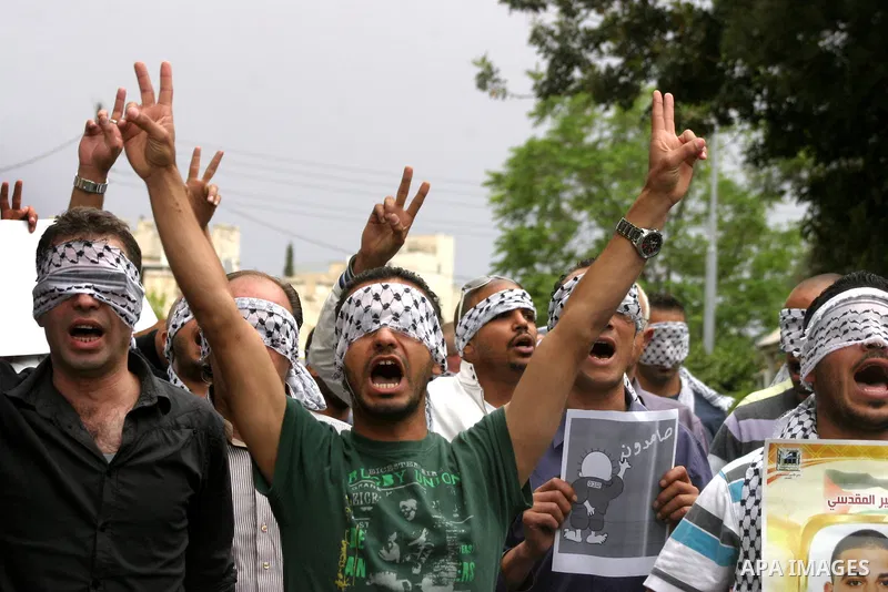Palestinians hold pictures and portraits of their relatives held in Israeli jails during a protest in solidarity with prisoners on hunger strike, in Jerusalem, May 10, 2012. Photo by Mahfouz Abu Turk