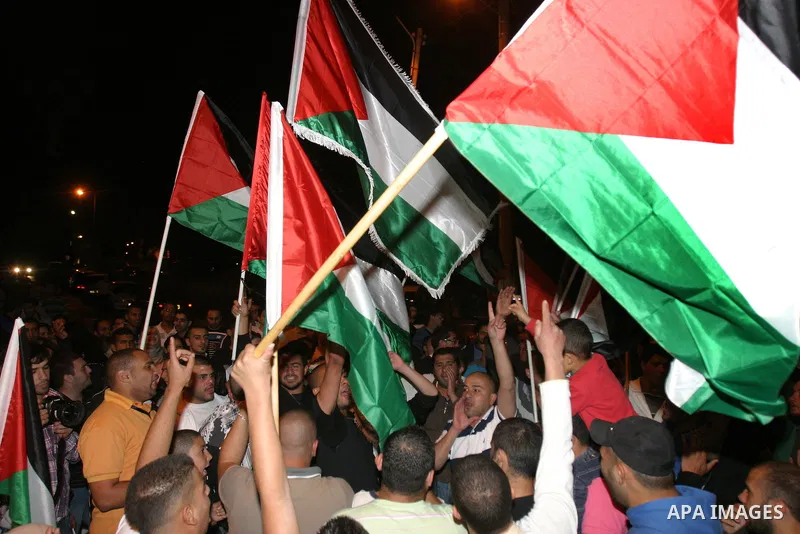 Palestinian hold national flags during celebrate after the signing of a deal to end the prisoners hunger strike in Jerusalem on 14 May 2012. Israel and Palestinian signed an agreement 14 May ending a mass hunger strike b...