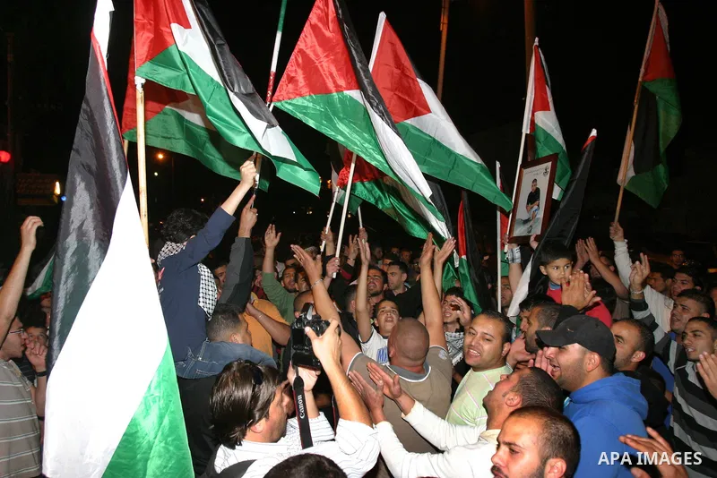 Palestinian hold national flags during celebrate after the signing of a deal to end the prisoners hunger strike in Jerusalem on 14 May 2012. Israel and Palestinian signed an agreement 14 May ending a mass hunger strike b...