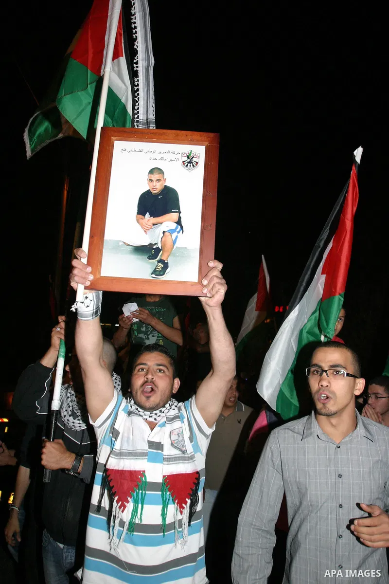 Palestinian hold national flags during celebrate after the signing of a deal to end the prisoners hunger strike in Jerusalem on 14 May 2012. Israel and Palestinian signed an agreement 14 May ending a mass hunger strike b...