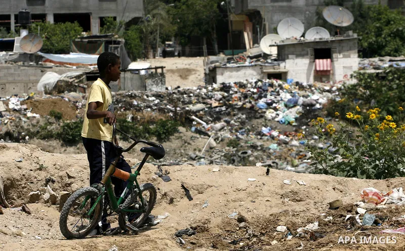 A Palestinian boy stands among the garbage in the Rafah Refugee Camp in the southern Gaza Strip, ahead of Nakba Day. on May 15, 2012. 'Nakba' Day for the Palestinians is an annual day of commemoration of the displacement...