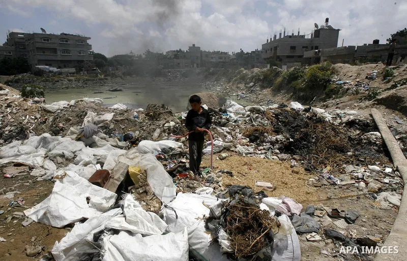A Palestinian boy stands among the garbage in the Rafah Refugee Camp in the southern Gaza Strip, ahead of Nakba Day. on May 15, 2012. 'Nakba' Day for the Palestinians is an annual day of commemoration of the displacement...