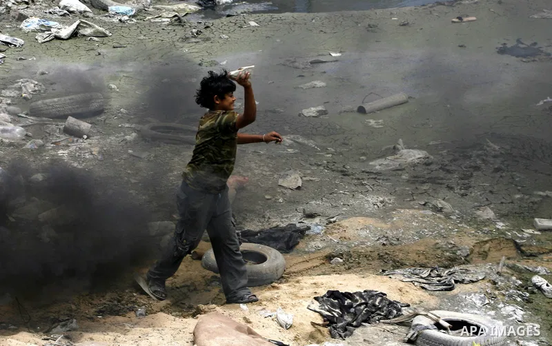 A Palestinian child burns tyres outside their home in the Rafah refugee camp in the southern Gaza Strip on May 13, 2012. on May 15, 2012. 'Nakba' Day for the Palestinians is an annual day of commemoration of the displace...
