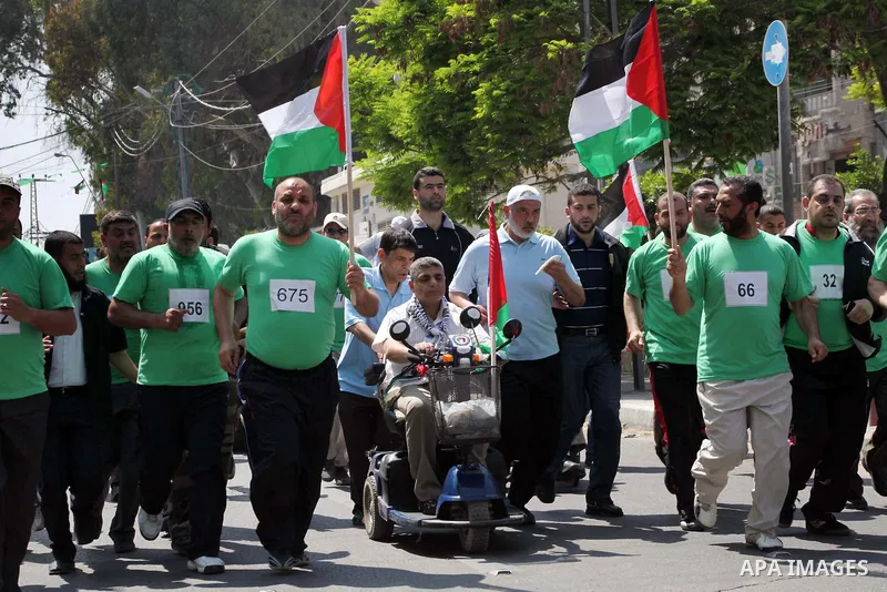 The head of Gaza's Hamas government, Ismail Haniya (blue polo shirt), takes part in a marathonin Gaza on May 15, 2012. 'Nakba' Day for the Palestinians is an annual day of commemoration of the displacement that followed...