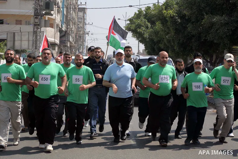 The head of Gaza's Hamas government, Ismail Haniya (blue polo shirt), takes part in a marathonin Gaza on May 15, 2012. 'Nakba' Day for the Palestinians is an annual day of commemoration of the displacement that followed...
