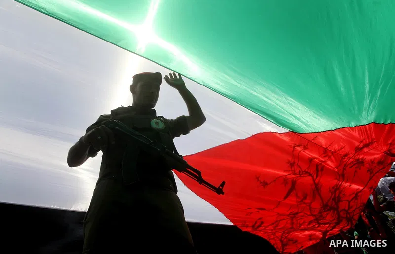 Palestinian Hamas security walk under a large Palestinian flag during a rally marking Al-Nakba, commemorating the displacement of Palestinians in 1948 due to the declaration of the state of Israel, in Gaza City, Gaza Str...