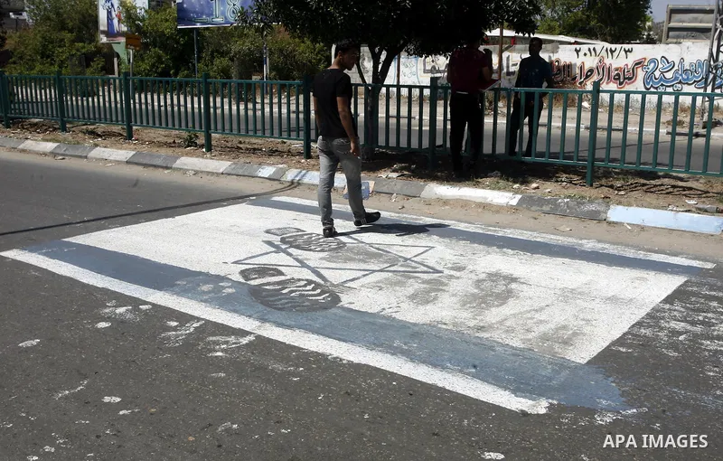 A Palestinian man walks on Israeli flag which painted by Palestinian artist paint marking Nakba in Gaza City May 15, 2012. Palestinians mark Nakba, or catastrophe, of Israel's founding in a 1948 war, when hundreds of tho...