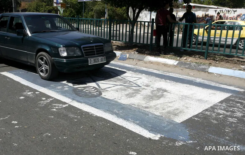 Palestinian cars walk on Israeli flag which painted by Palestinian artist paint marking Nakba in Gaza City May 15, 2012. Palestinians mark Nakba, or catastrophe, of Israel's founding in a 1948 war, when hundreds of thous...