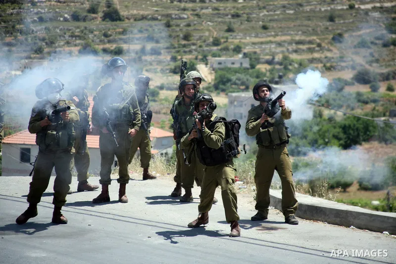 Israeli soldiers fire teargas, towards Palestinian stone throwers deployed at the entrance of the al-Aroub Palestinian refugee camp, just north the West Bank town of Hebron on May 15, 2012, as Palestinians mark Nakba day...