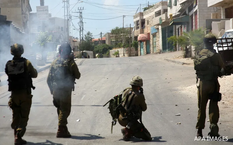 Israeli soldiers fire teargas, towards Palestinian stone throwers deployed at the entrance of the al-Aroub Palestinian refugee camp, just north the West Bank town of Hebron on May 15, 2012, as Palestinians mark Nakba day...