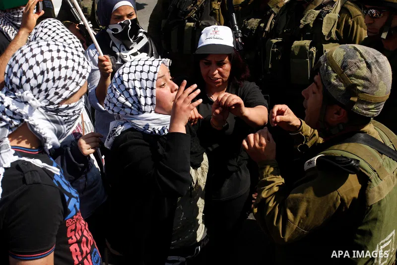 Israeli soldiers stand face to Palestinian and foreign activists who hold Palestinian flags during a demonstration marking the 64th anniversary of the 'Nakba' ('catastrophe'), at the Hawara checkpoint near the West Bank...