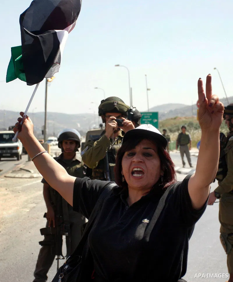 Israeli soldiers stand face to Palestinian and foreign activists who hold Palestinian flags during a demonstration marking the 64th anniversary of the 'Nakba' ('catastrophe'), at the Hawara checkpoint near the West Bank...