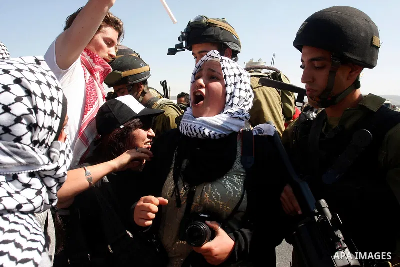 Israeli soldiers stand face to Palestinian and foreign activists who hold Palestinian flags during a demonstration marking the 64th anniversary of the 'Nakba' ('catastrophe'), at the Hawara checkpoint near the West Bank...