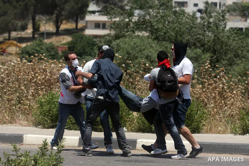 Palestinians carry an injured demonstrator, during clashes on Nakba Day near Ofer prison, near Ramallah, the West Bank, 15 May 2012. Thousands marched in the West Bank and Gaza Strip, commemorating the dispersal of hundr...