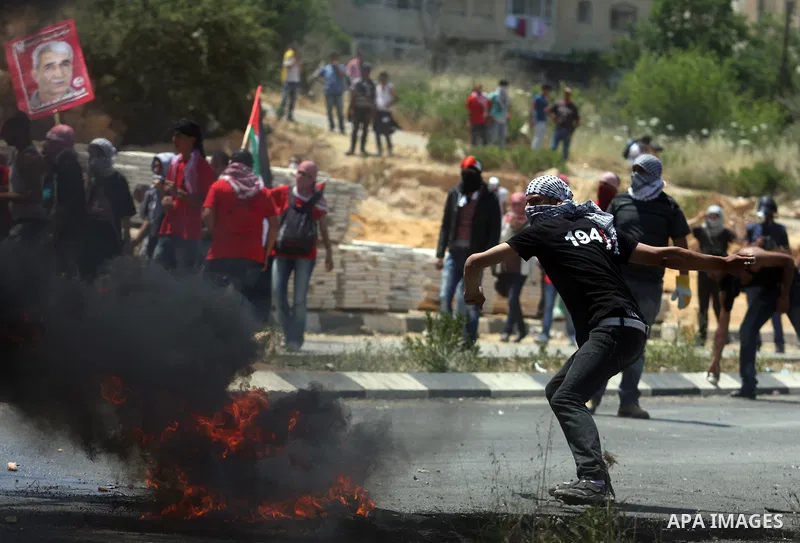 Palestinian protesters throw stones towards Israeli border police during clashes on Nakba Day near Ofer prison, near Ramallah, the West Bank, 15 May 2012. Thousands marched in the West Bank and Gaza Strip, commemorating...