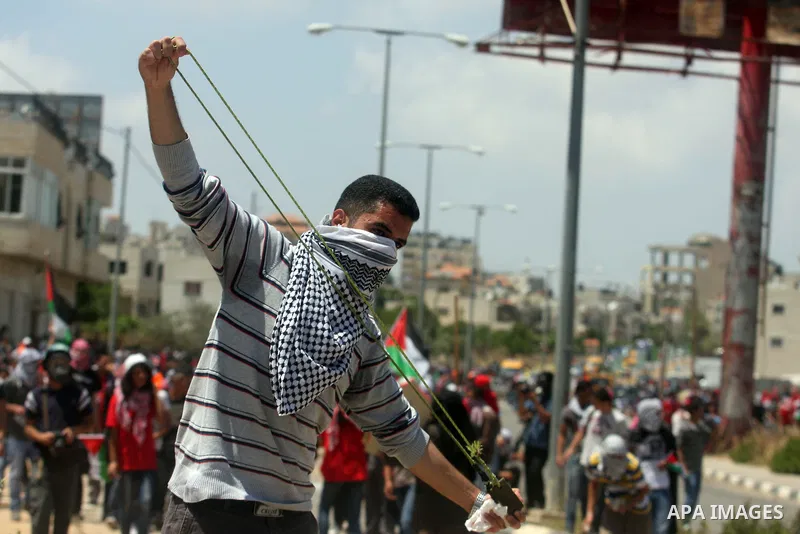 Palestinian protesters throw stones towards Israeli border police during clashes on Nakba Day near Ofer prison, near Ramallah, the West Bank, 15 May 2012. Thousands marched in the West Bank and Gaza Strip, commemorating...