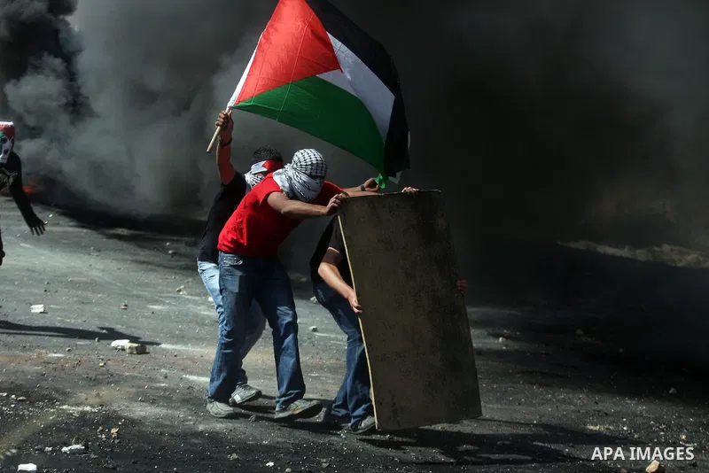 Palestinian stone throwers try to avoid tear gas fired by Israeli soldiers, during clashes on Nakba Day near Ofer prison, near Ramallah, the West Bank, 15 May 2012. Thousands marched in the West Bank and Gaza Strip, comm...