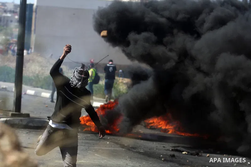 Palestinian protesters throw stones towards Israeli border police during clashes on Nakba Day near Ofer prison, near Ramallah, the West Bank, 15 May 2012. Thousands marched in the West Bank and Gaza Strip, commemorating...