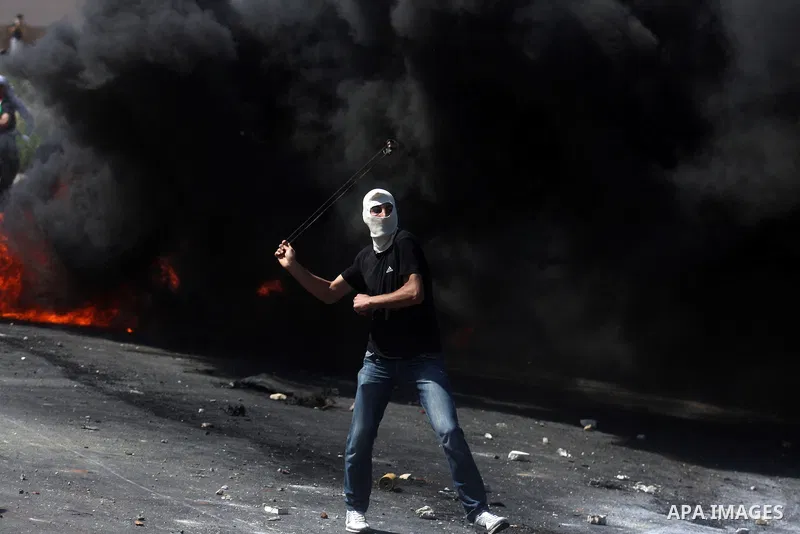 Palestinian protesters throw stones towards Israeli border police during clashes on Nakba Day near Ofer prison, near Ramallah, the West Bank, 15 May 2012. Thousands marched in the West Bank and Gaza Strip, commemorating...