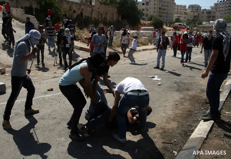 Palestinians carry an injured demonstrator, during clashes on Nakba Day near Ofer prison, near Ramallah, the West Bank, 15 May 2012. Thousands marched in the West Bank and Gaza Strip, commemorating the dispersal of hundr...