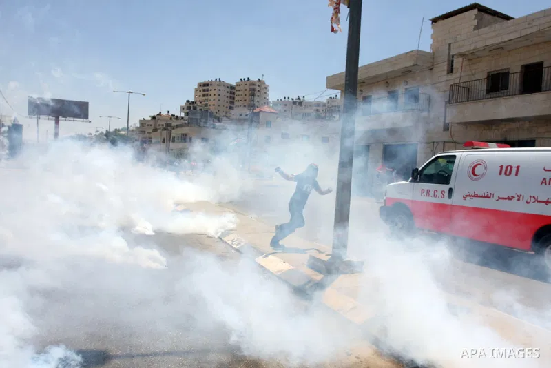 Palestinian stone throwers try to avoid tear gas fired by Israeli soldiers, during clashes on Nakba Day near Ofer prison, near Ramallah, the West Bank, 15 May 2012. Thousands marched in the West Bank and Gaza Strip, comm...