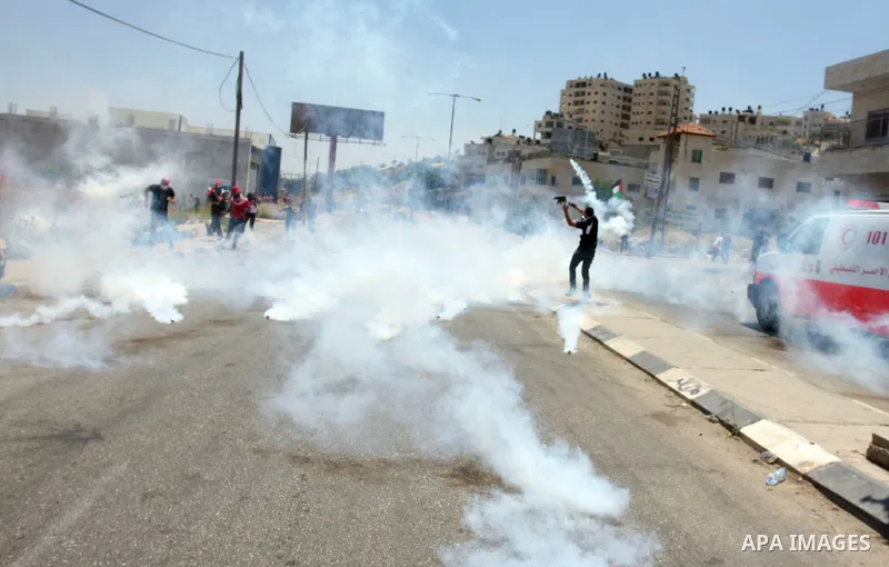 Palestinian stone throwers try to avoid tear gas fired by Israeli soldiers, during clashes on Nakba Day near Ofer prison, near Ramallah, the West Bank, 15 May 2012. Thousands marched in the West Bank and Gaza Strip, comm...