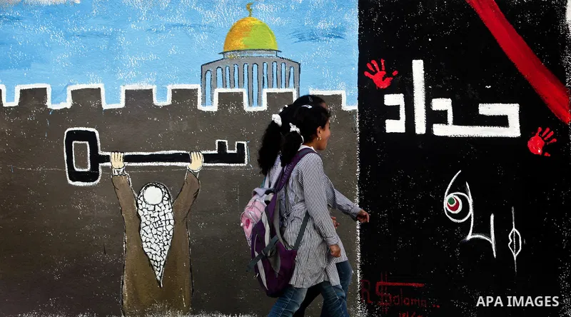 School girls walk past newly painted mural on the 64th anniversary of "Nakba", Arabic for catastrophe, the term used to mark the events leading to Israel's founding in 1948, in Gaza City, Tuesday, May 15, 2012. Hundreds...