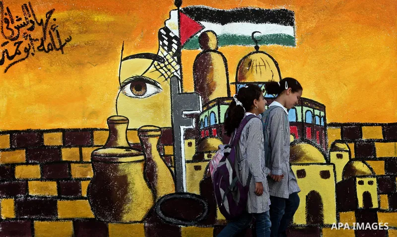 School girls walk past newly painted mural on the 64th anniversary of "Nakba", Arabic for catastrophe, the term used to mark the events leading to Israel's founding in 1948, in Gaza City, Tuesday, May 15, 2012. Hundreds...